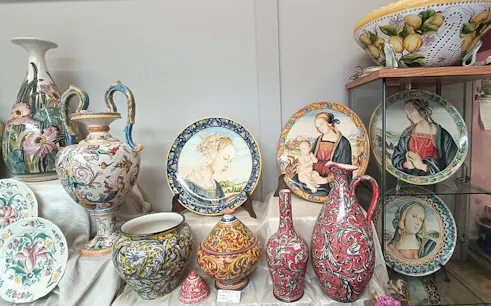 Florence artisan ceramics with painted plates and vases on display during workshop tour.