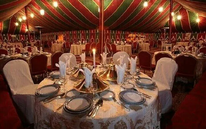Dining setup under colorful tent for Chez Ali Fantasia folklore show, Marrakesh.