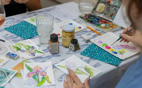 Painting class setup with watercolor supplies and floral artwork in Florence.