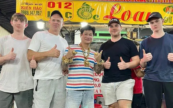 Group of tourists with a local guide on a Ho Chi Minh City motorbike street food tour.