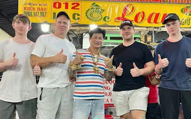 Group of tourists with a local guide on a Ho Chi Minh City motorbike street food tour.