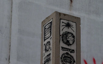 Street art on a concrete pillar in Reykjavik alley during guided walking tour.