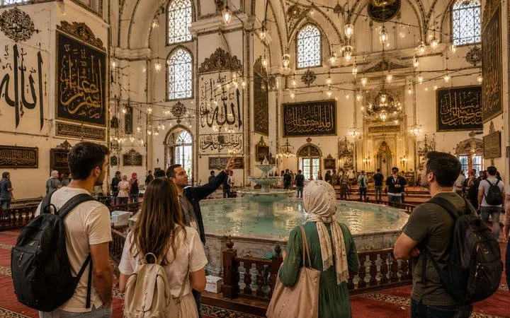 Tour group inside Ulu Mosque, Bursa, viewing ornate calligraphy and central fountain.