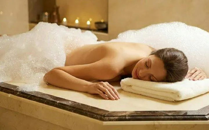 Traditional hammam experience with foam massage in Marrakech spa setting.