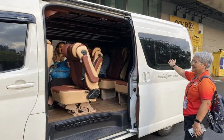 Tour guide showing luxury van for Private Pattaya Day Tour from Bangkok.