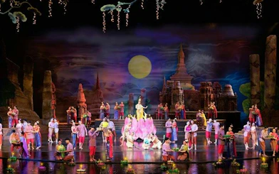 Performers on stage at Siam Niramit Phuket, depicting Thai cultural scenes with traditional costumes.