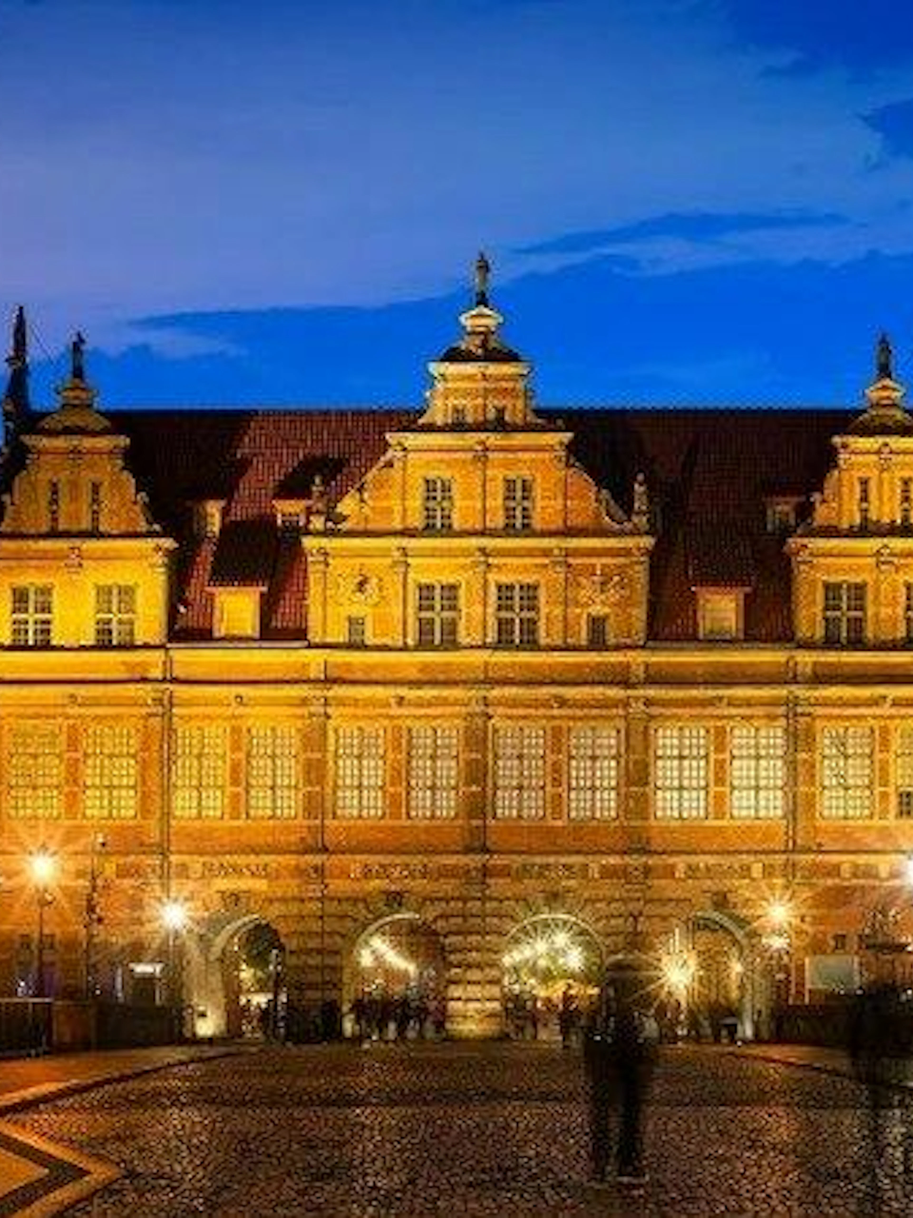 Gdansk's Golden Gate illuminated at dusk during self-guided audio walking tour.
