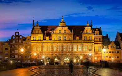 Gdansk's Golden Gate illuminated at dusk during self-guided audio walking tour.