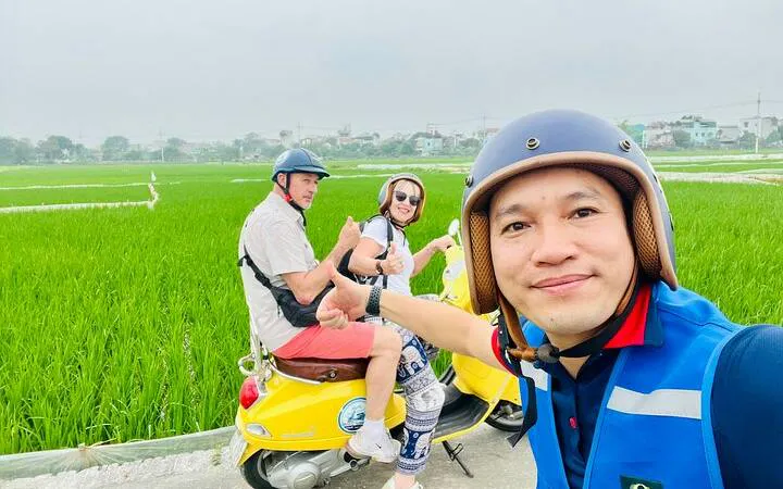 Tourists on a Vespa in Hanoi countryside near Co Loa Citadel.