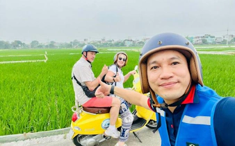 Tourists on a Vespa in Hanoi countryside near Co Loa Citadel.
