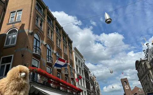 Historic buildings and Dutch flags in a street view, Brussels, on a sunny day.