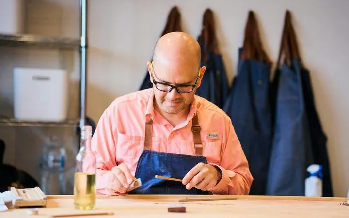 Man crafting chopsticks at a workshop in Kyoto, Japan.