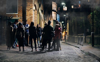 Group on Jack the Ripper walking tour in London, exploring historic streets at night.