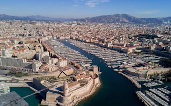 Aerial view of Marseille's Old Port with Fort Saint-Jean, France, on a sunny day.