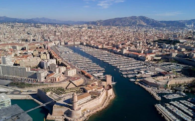 Aerial view of Marseille's Old Port with Fort Saint-Jean, France, on a sunny day.