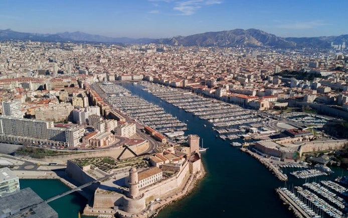 Aerial view of Marseille's Old Port with Fort Saint-Jean, France, on a sunny day.