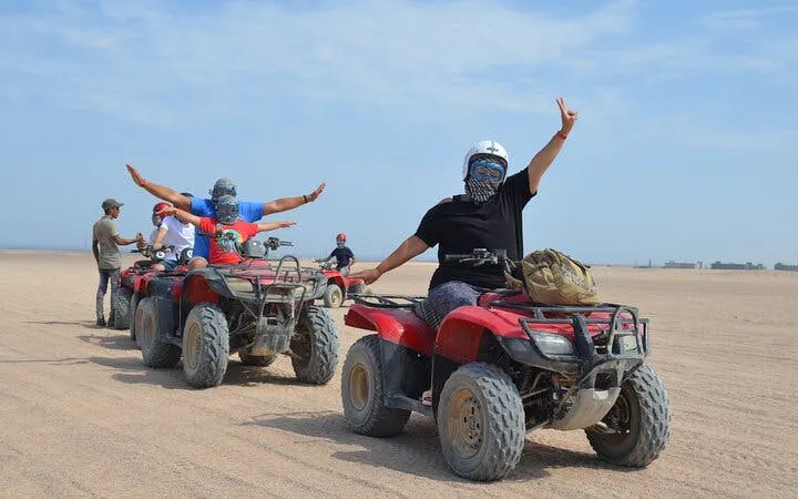 Quad bike riders in desert near Hurghada during safari tour.