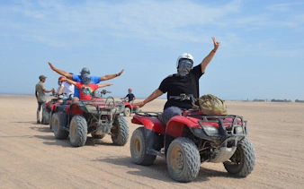 Quad bike riders in desert near Hurghada during safari tour.