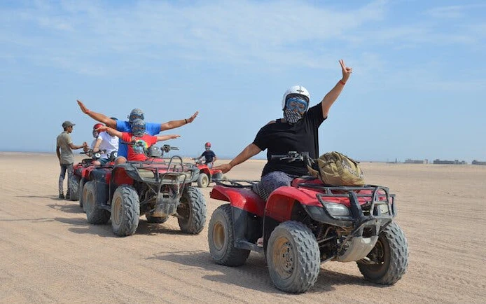 Quad bike riders in desert near Hurghada during safari tour.