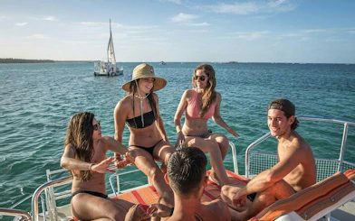 Group enjoying a catamaran cruise with drinks in Punta Cana's natural reserve.