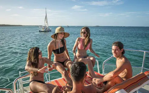 Group enjoying a catamaran cruise with drinks in Punta Cana's natural reserve.