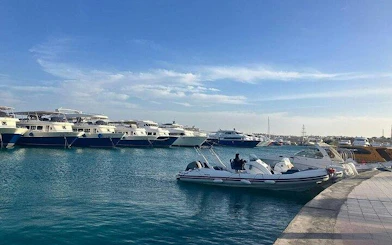 Boats docked at a marina in Hurghada, Egypt, under a clear sky.