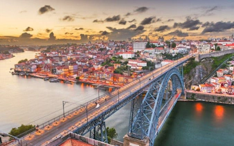 Porto cityscape with Dom Luís I Bridge at sunset, view from self-guided walking tour app.