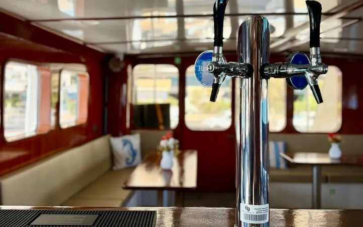 Interior of a boat with seating and a drink tap, part of the Round Malta Boat Cruise.