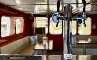 Interior of a boat with seating and a drink tap, part of the Round Malta Boat Cruise.