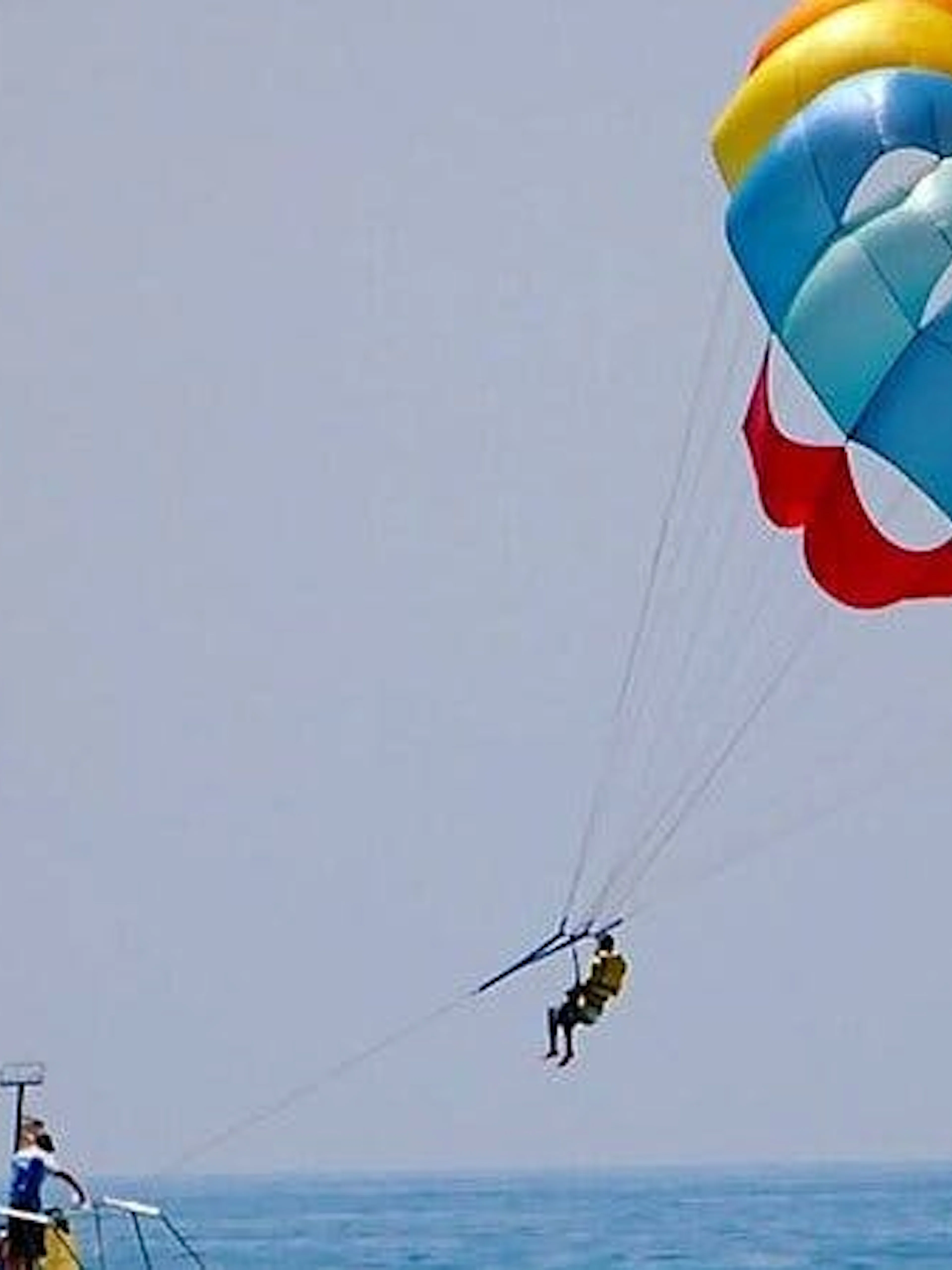 Parasailing over the Red Sea with colorful parachute, towed by speedboat in Hurghada.