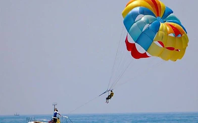 Parasailing over the Red Sea with colorful parachute, towed by speedboat in Hurghada.