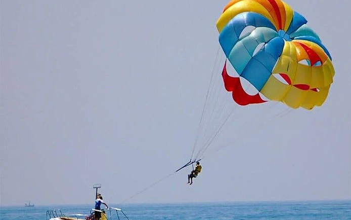 Parasailing over the Red Sea with colorful parachute, towed by speedboat in Hurghada.