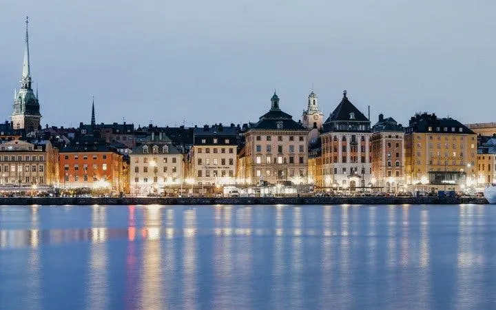 Stockholm waterfront view with historic buildings during evening, part of self-guided walking tour.