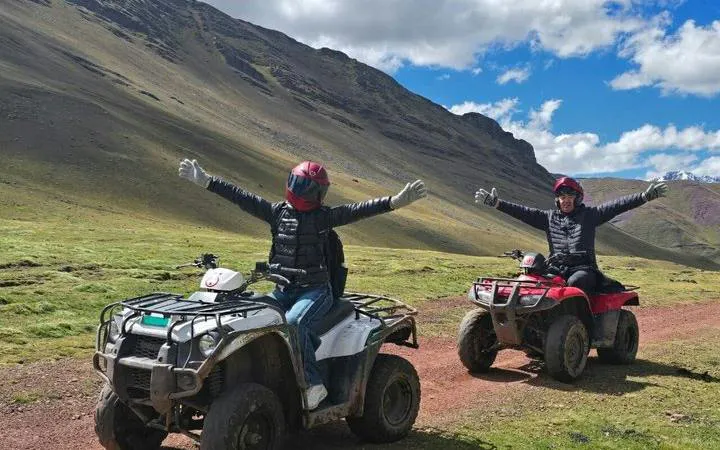 ATV riders on a trail near Rainbow Mountain, Cusco, with scenic mountain views.