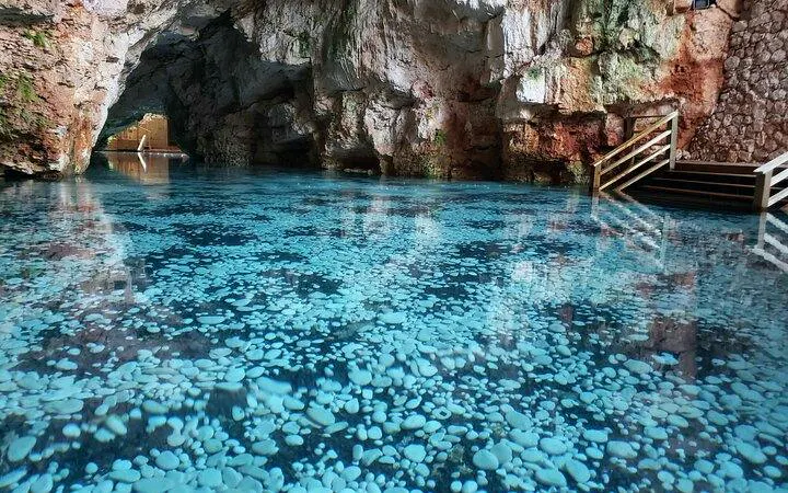 Cenote cave with clear blue water and rocky walls at Taino Park, Punta Cana.