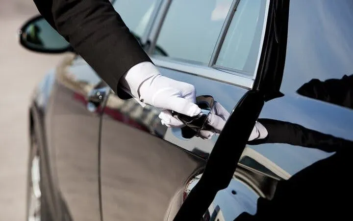 Chauffeur opening car door for airport transfer in Hurghada.