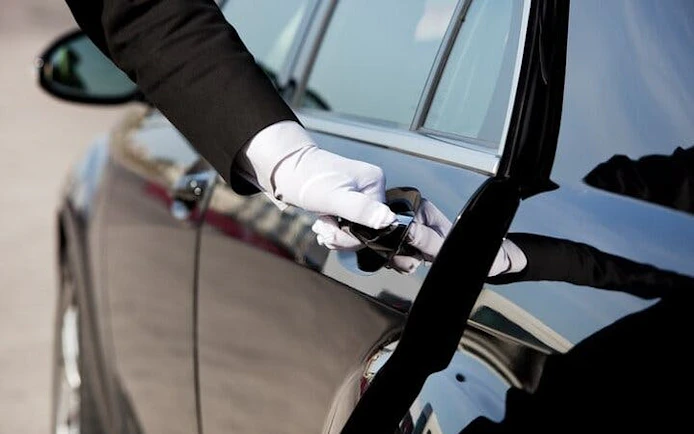 Chauffeur opening car door for airport transfer in Hurghada.