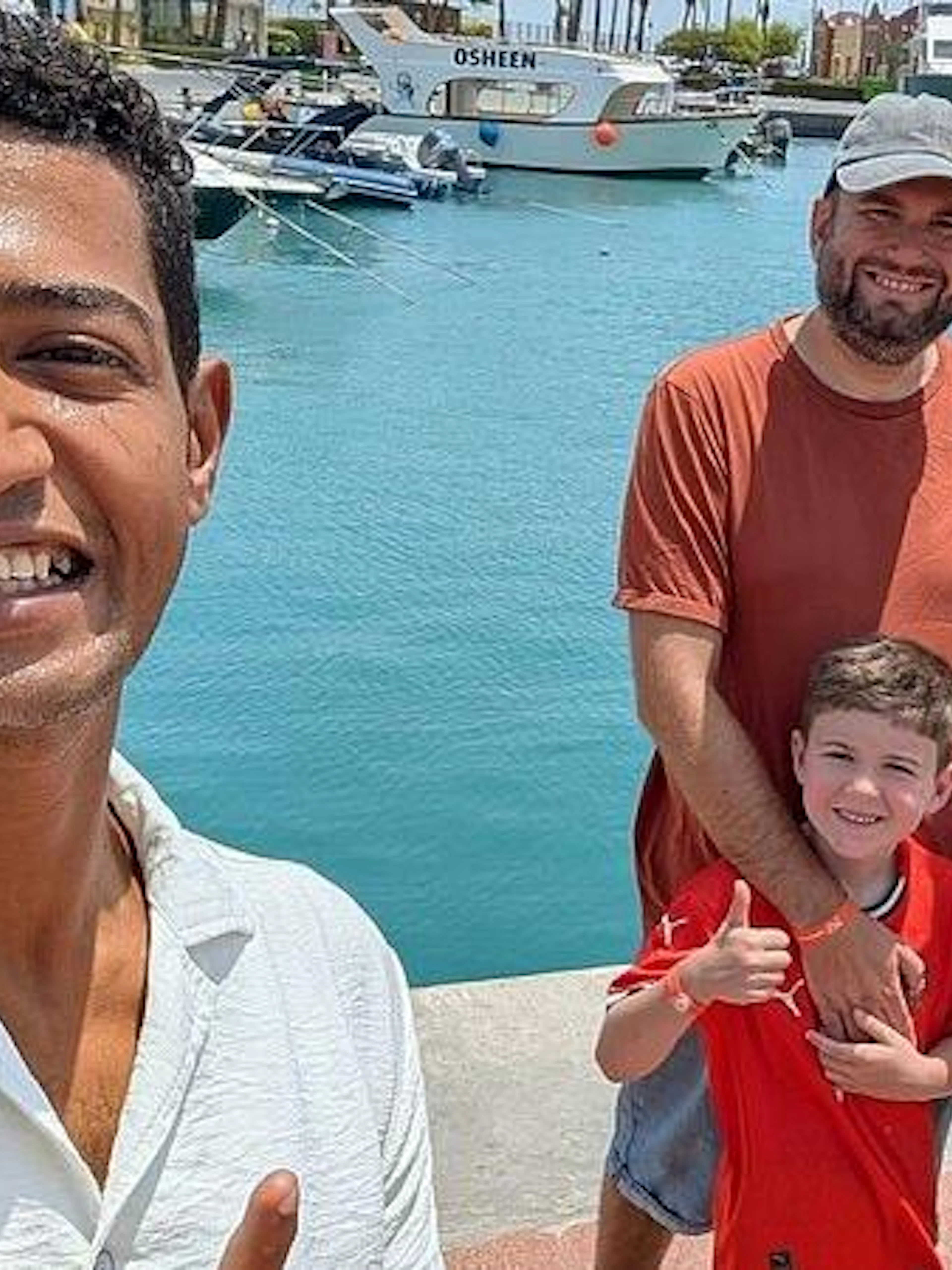 Family with guide at Hurghada marina, boats in background, during private tour.