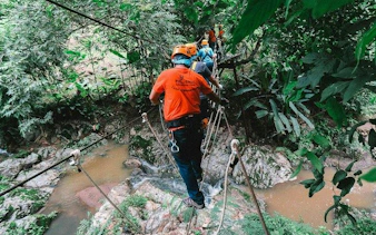Participants crossing a rope bridge at Phoenix Zipline Adventure Park, Chiang Mai.