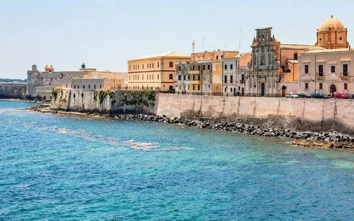 Syracuse waterfront with historic buildings and clear blue sea, Siracusa self-guided walking tour.