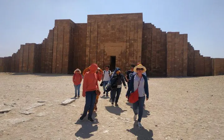 Tourists exploring the ancient Saqqara complex in Egypt on a guided tour.