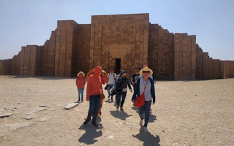 Tourists exploring the ancient Saqqara complex in Egypt on a guided tour.