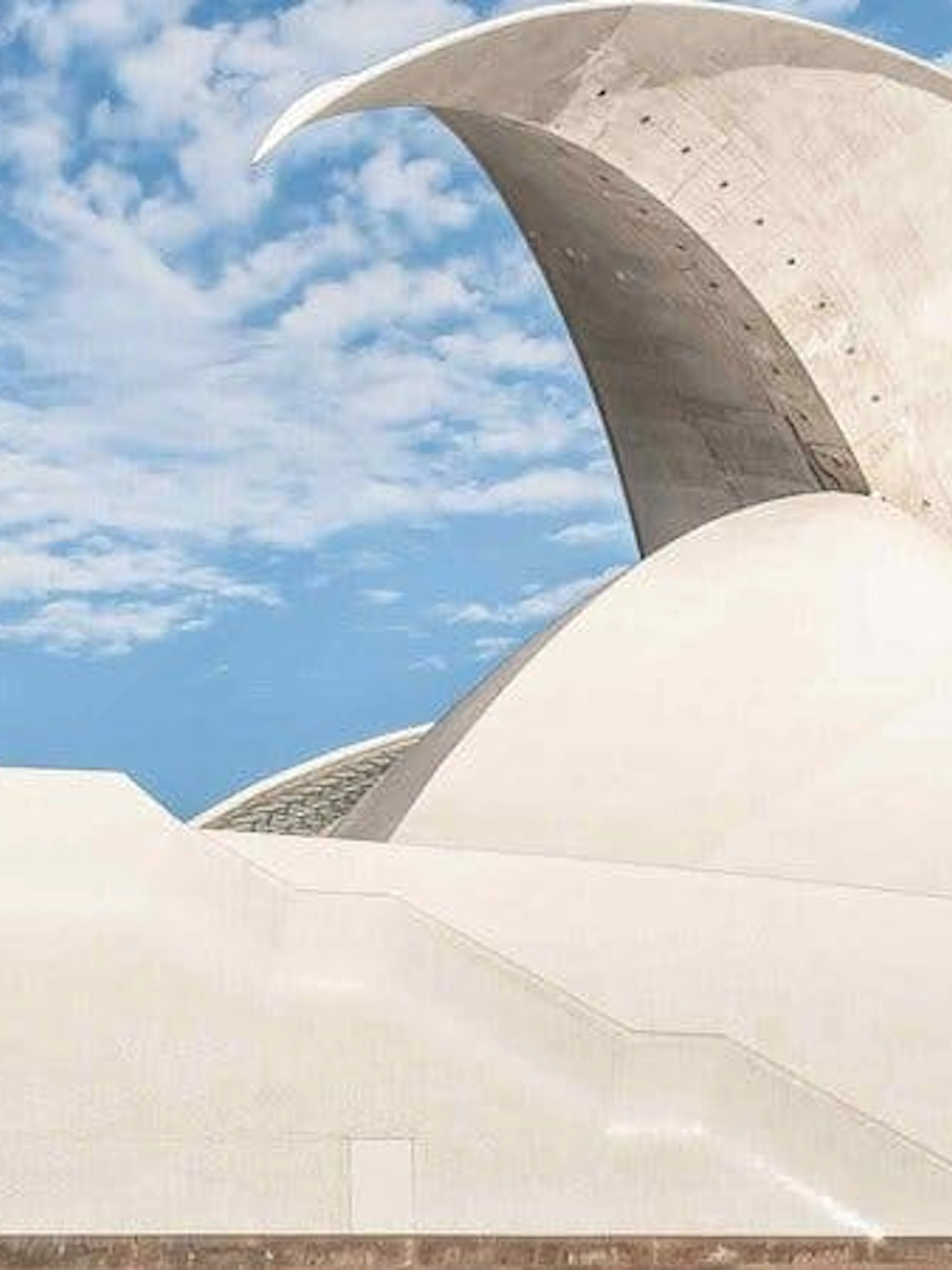 Auditorio de Tenerife with curved roof against blue sky.