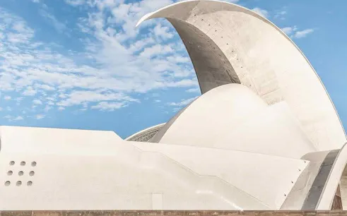 Auditorio de Tenerife with curved roof against blue sky.
