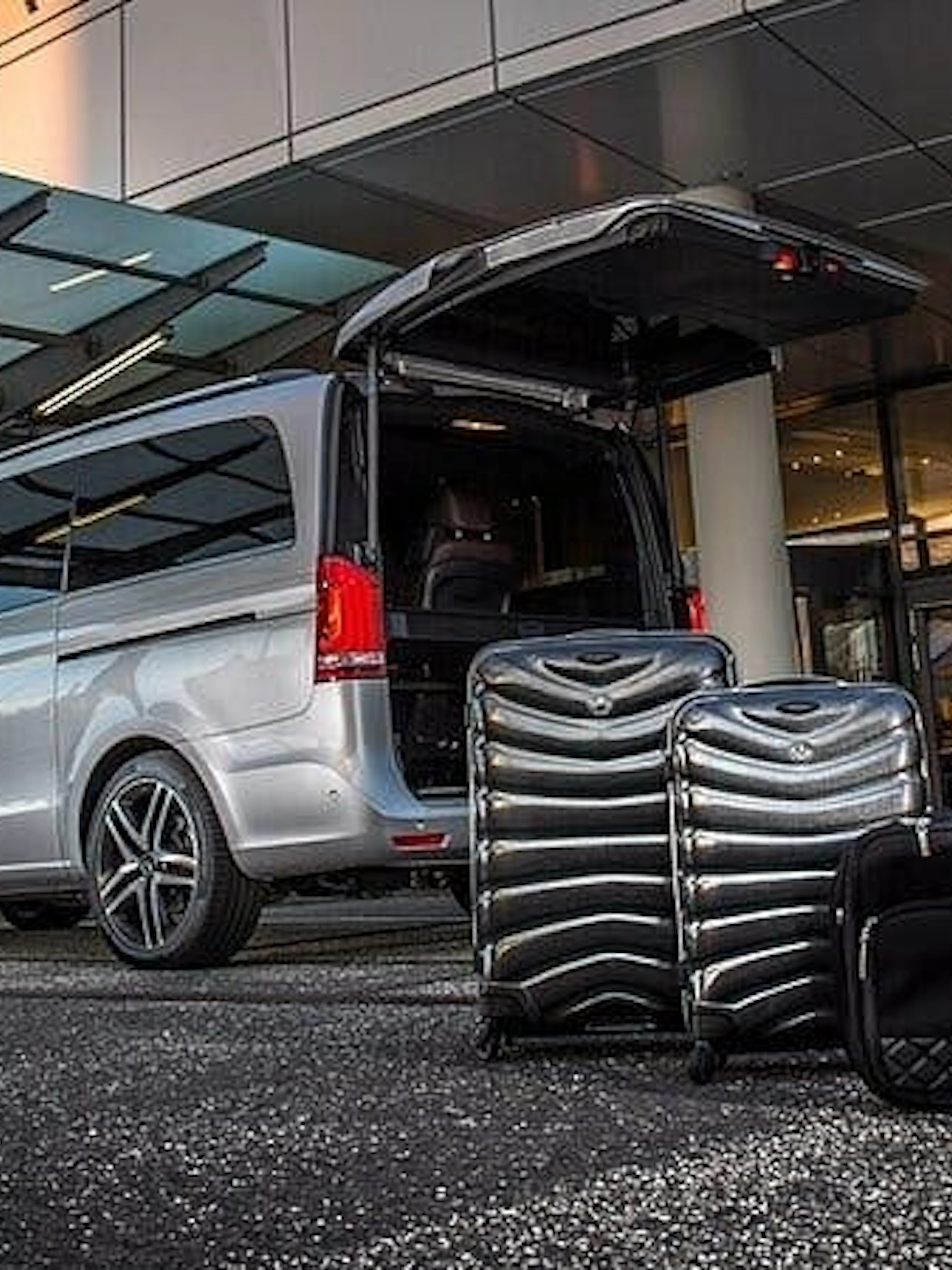 Van with open trunk and luggage at airport terminal for Hurghada hotel transfer service.