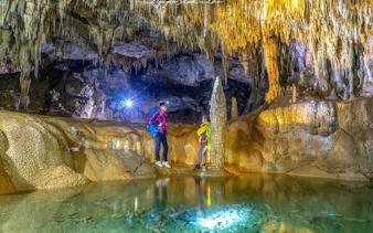 Visitors exploring a cave with stalactites and stalagmites on the Sapa Nature Day Trip.