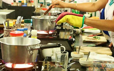 Cooking class participants stirring pots at Baan Hongnual, Chiang Mai.