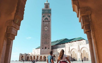 Hassan II Mosque in Casablanca with visitors, viewed from an archway.