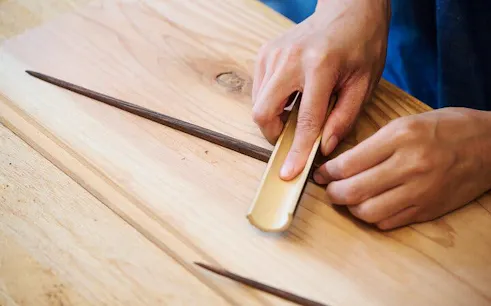 Hands crafting chopsticks in Tokyo Ginza workshop.