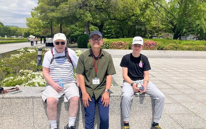 Tour guide with visitors at Hiroshima Peace Memorial Park.
